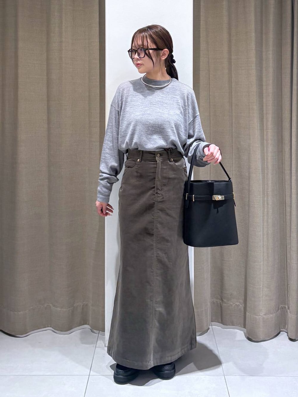 ブラウン系のテーラードジャケット、グレー系のニット/セーター、ブラウン系のスカートを着用したレディースの秋コーディネートの5枚目の写真