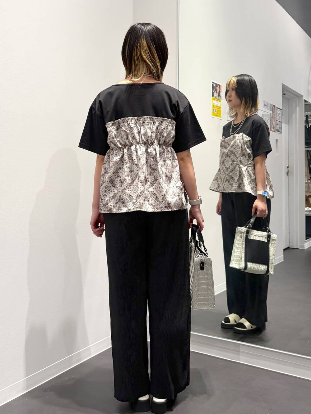 ホワイト系のショルダーバッグ、ホワイト系のサンダル、ブラック系のTシャツ/カットソーを着用したレディースの春コーディネートの3枚目の写真