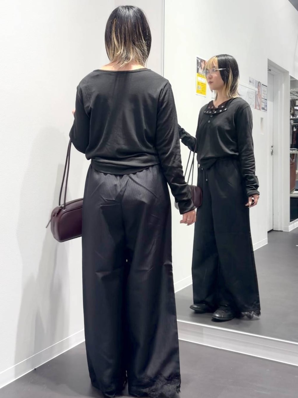 レッド系のボストンバッグ、ブラック系のスラックス、ブラック系のTシャツ/カットソーを着用したレディースの夏コーディネートの3枚目の写真