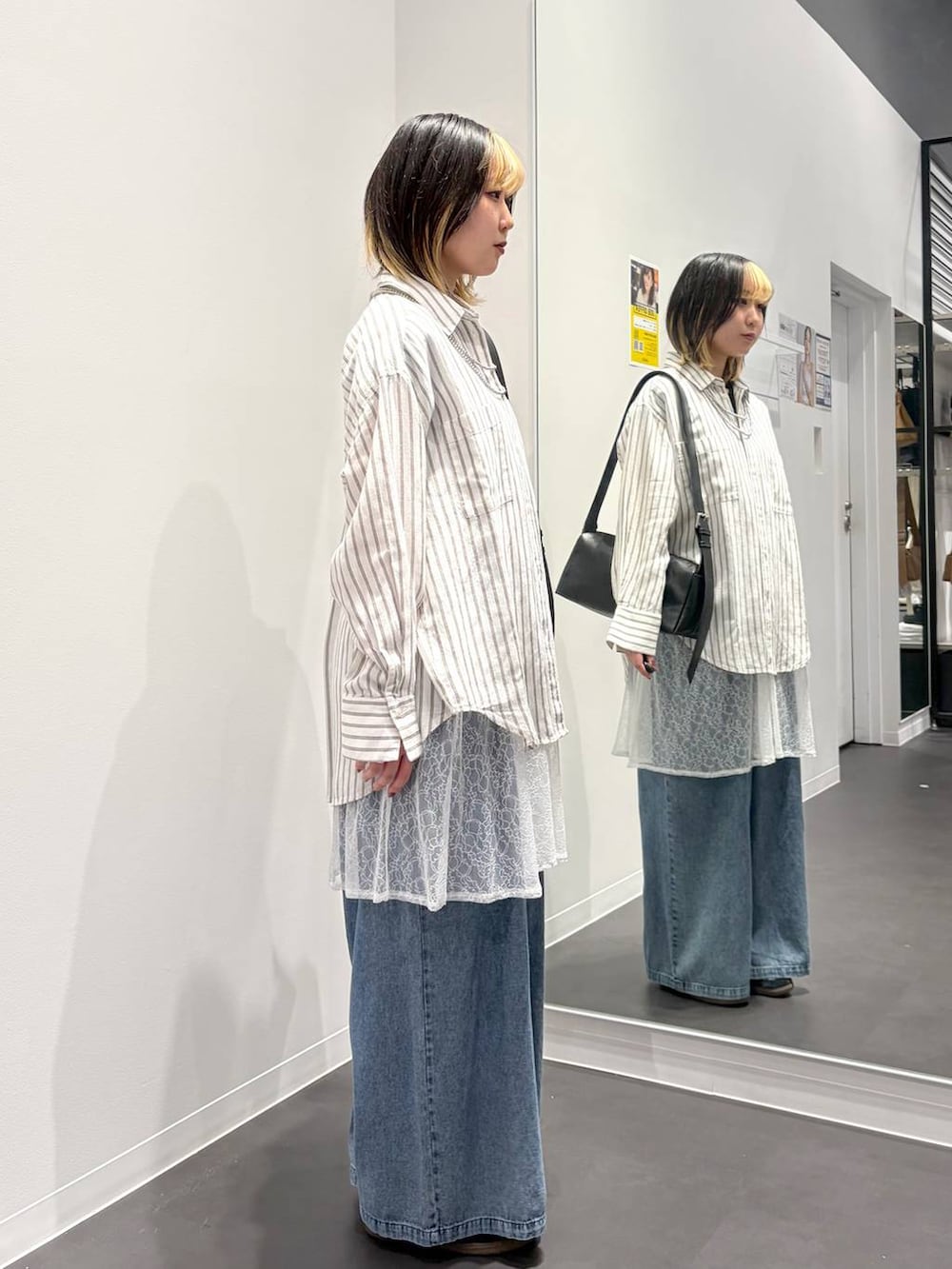 ブラック系のショルダーバッグ、ホワイト系のシャツ/ブラウス、ブルー系のデニムパンツを着用したレディースの春コーディネートの4枚目の写真