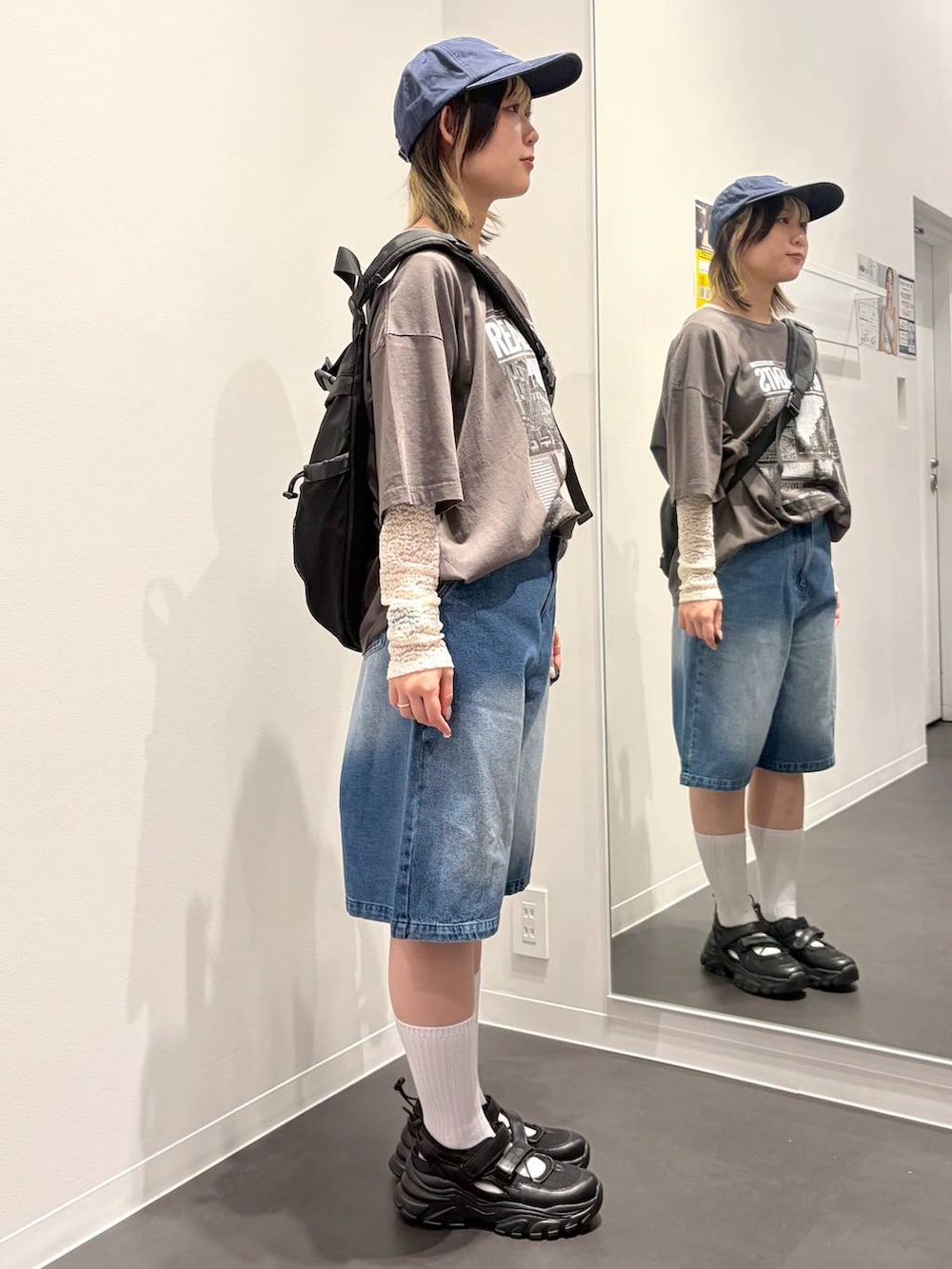 ブラック系のスニーカー、ブラック系のボディバッグ/ウエストポーチ、ホワイト系のTシャツ/カットソーを着用したレディースの春コーディネートの4枚目の写真