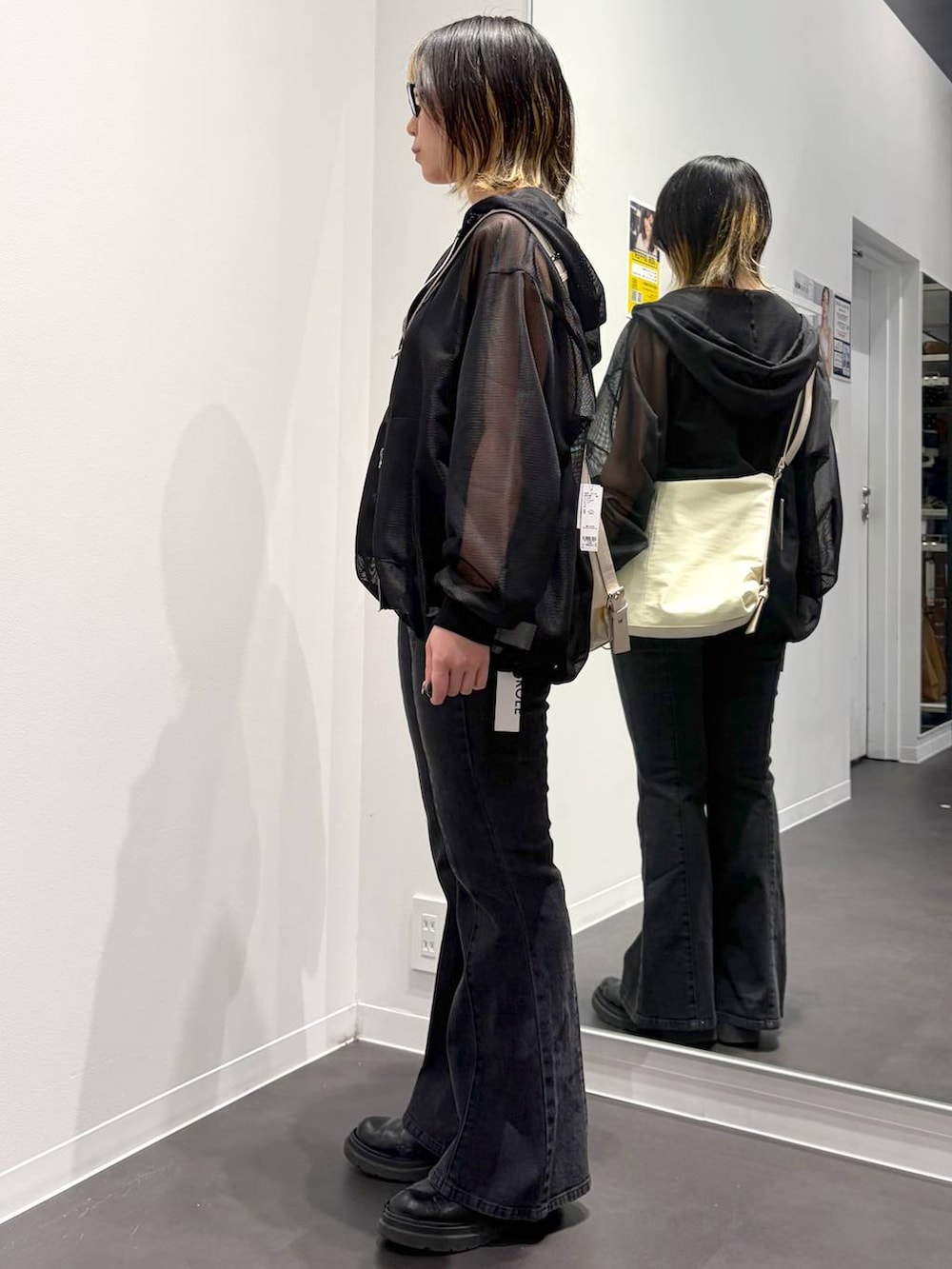 ホワイト系のショルダーバッグ、ブラック系のデニムパンツ、ブラック系のタンクトップを着用したレディースの春コーディネートの4枚目の写真