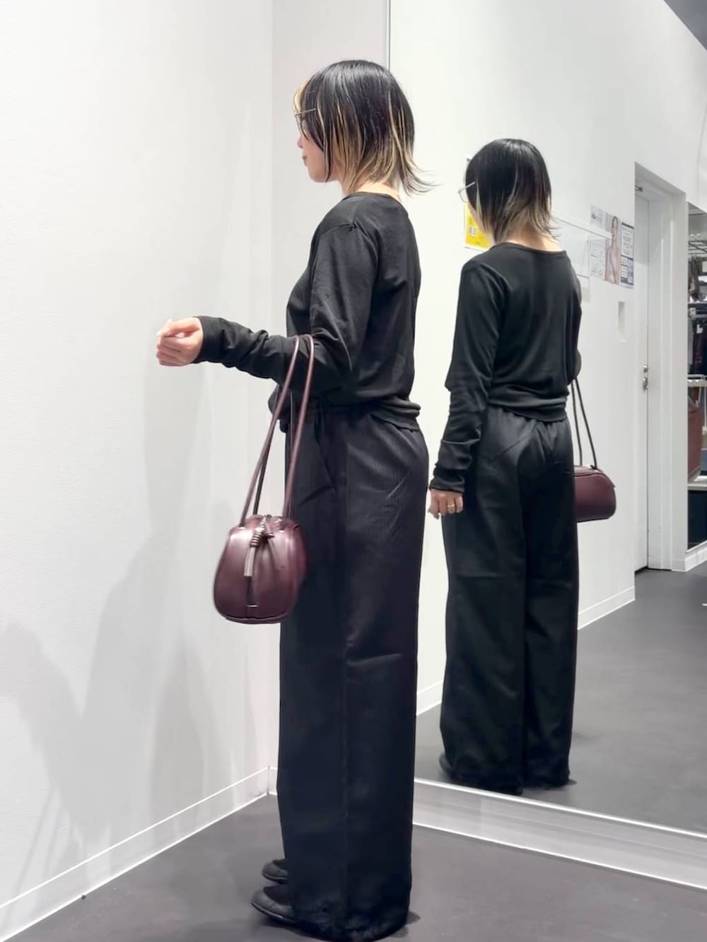 レッド系のボストンバッグ、ブラック系のスラックス、ブラック系のTシャツ/カットソーを着用したレディースの夏コーディネートの2枚目の写真