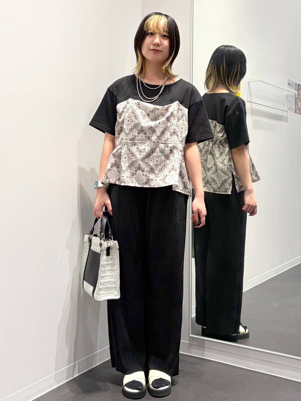 ホワイト系のショルダーバッグ、ホワイト系のサンダル、ブラック系のTシャツ/カットソーを着用したレディースの春コーディネートの5枚目の写真