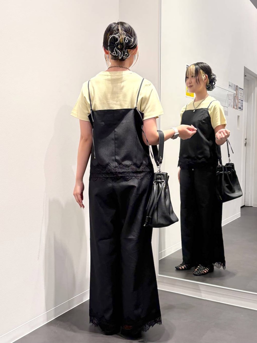ブラック系のスラックス、ブラック系のキャミソール、ブラック系のサンダルを着用したレディースの夏コーディネートの3枚目の写真