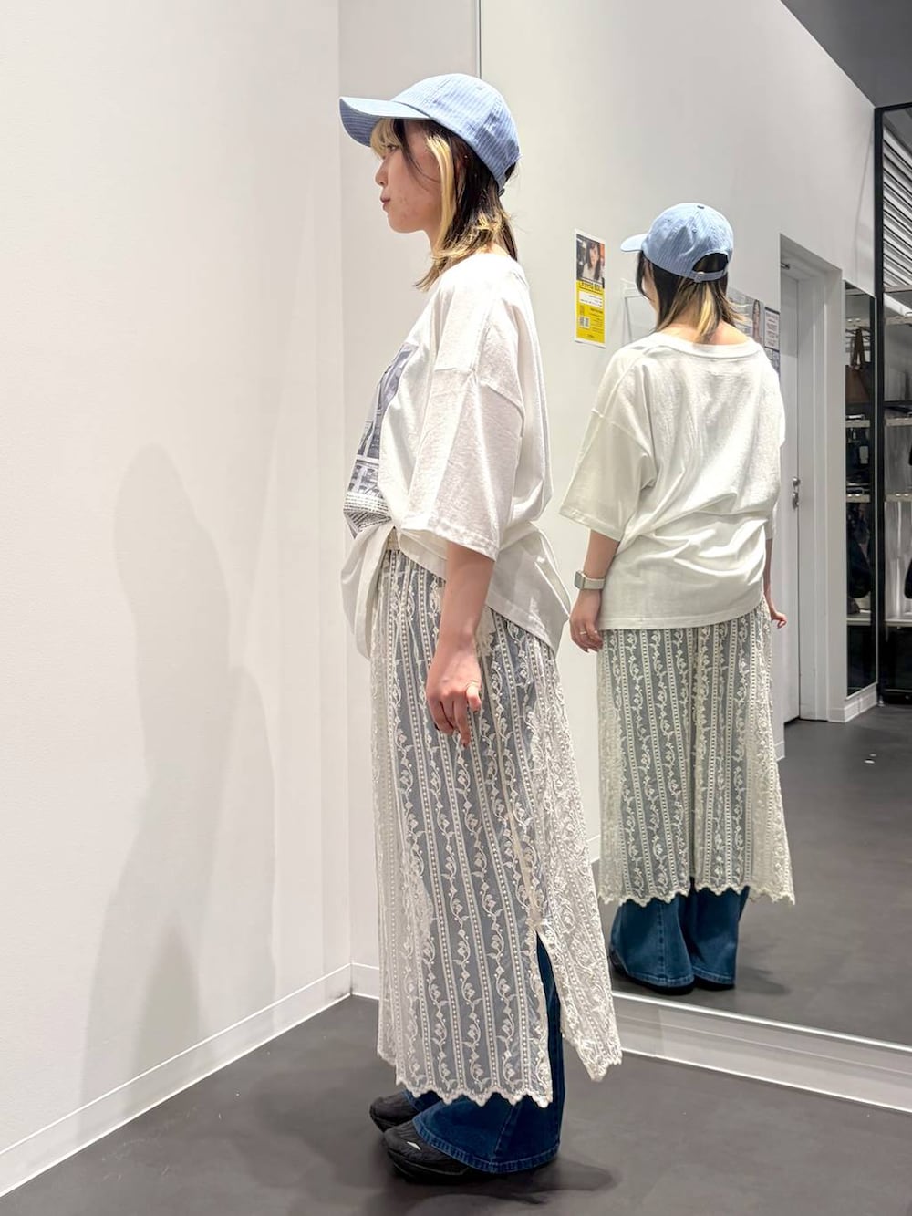 ブルー系のデニムパンツ、ホワイト系のTシャツ/カットソー、ベージュ系のスカートを着用したレディースの春コーディネートの2枚目の写真