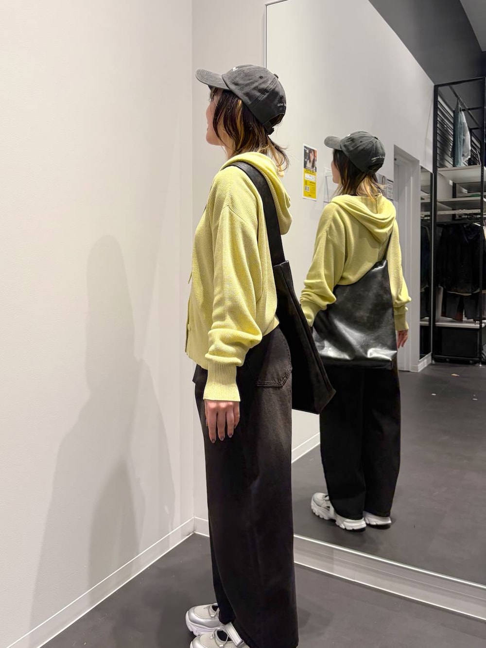 ブラック系のデニムパンツ、ブラック系のショルダーバッグ、シルバー系のスニーカーを着用したレディースの春コーディネートの2枚目の写真