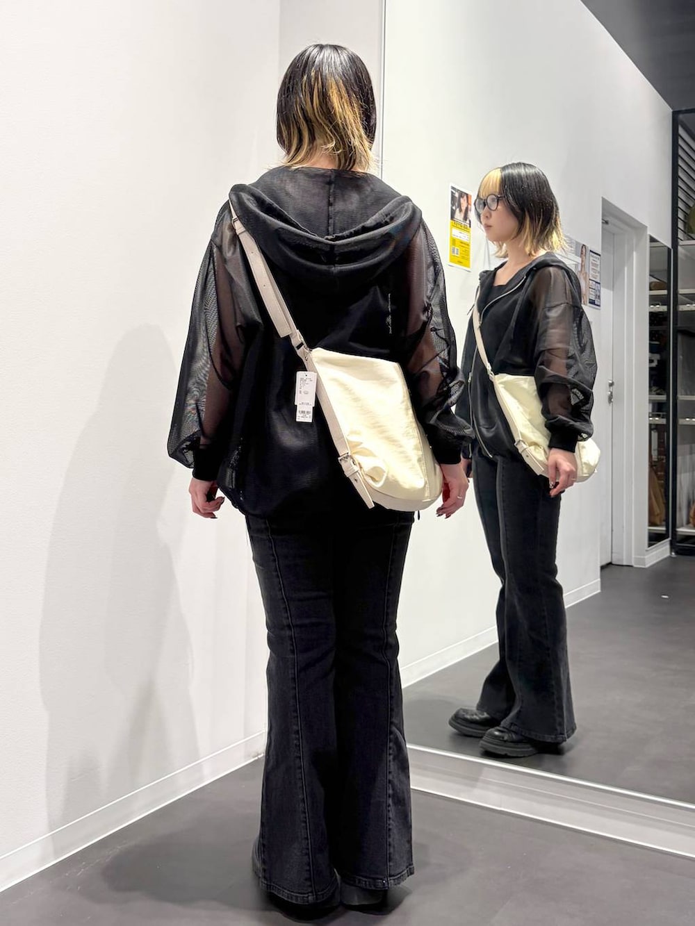 ホワイト系のショルダーバッグ、ブラック系のデニムパンツ、ブラック系のタンクトップを着用したレディースの春コーディネートの3枚目の写真