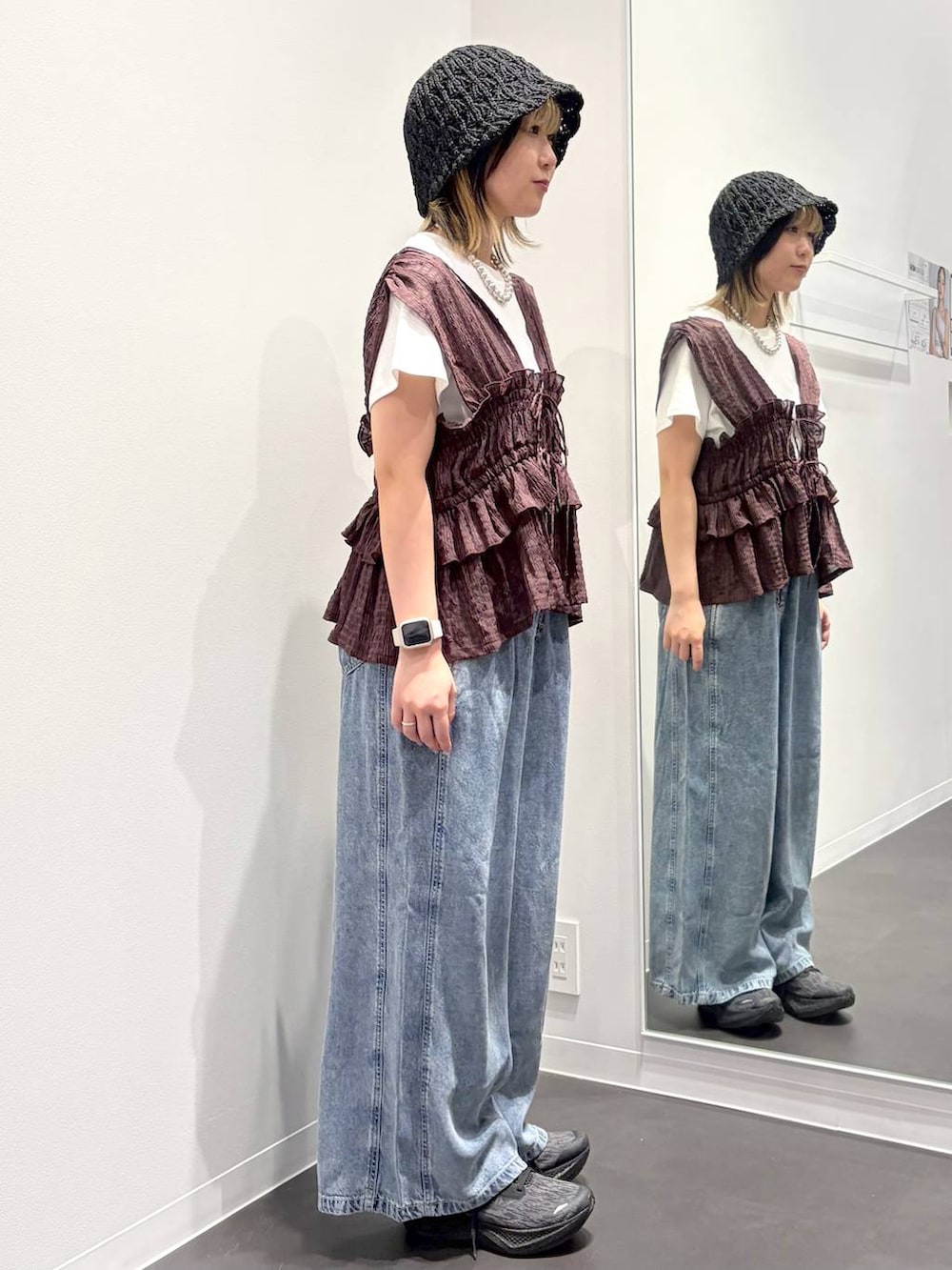 ブラウン系のベスト、ホワイト系のTシャツ/カットソー、ブルー系のデニムパンツを着用したレディースの夏コーディネートの4枚目の写真