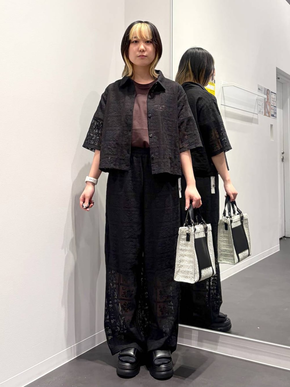 ホワイト系のショルダーバッグ、ブラック系のサンダル、ブラウン系のTシャツ/カットソーを着用したレディースの春コーディネートの5枚目の写真