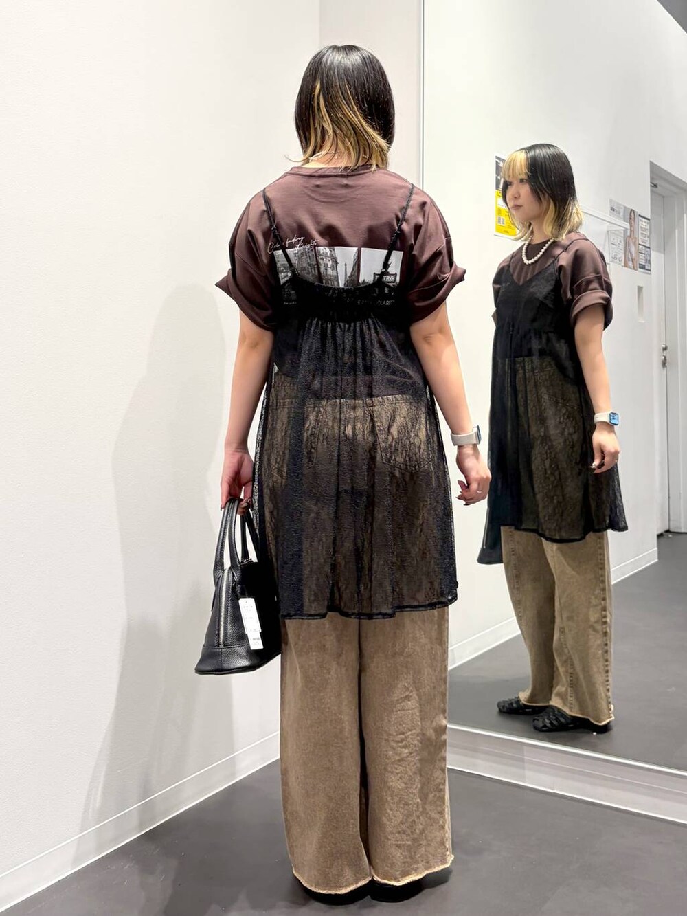 ブラック系のサンダル、ブラック系のハンドバッグ、ベージュ系のデニムパンツを着用したレディースの春コーディネートの3枚目の写真