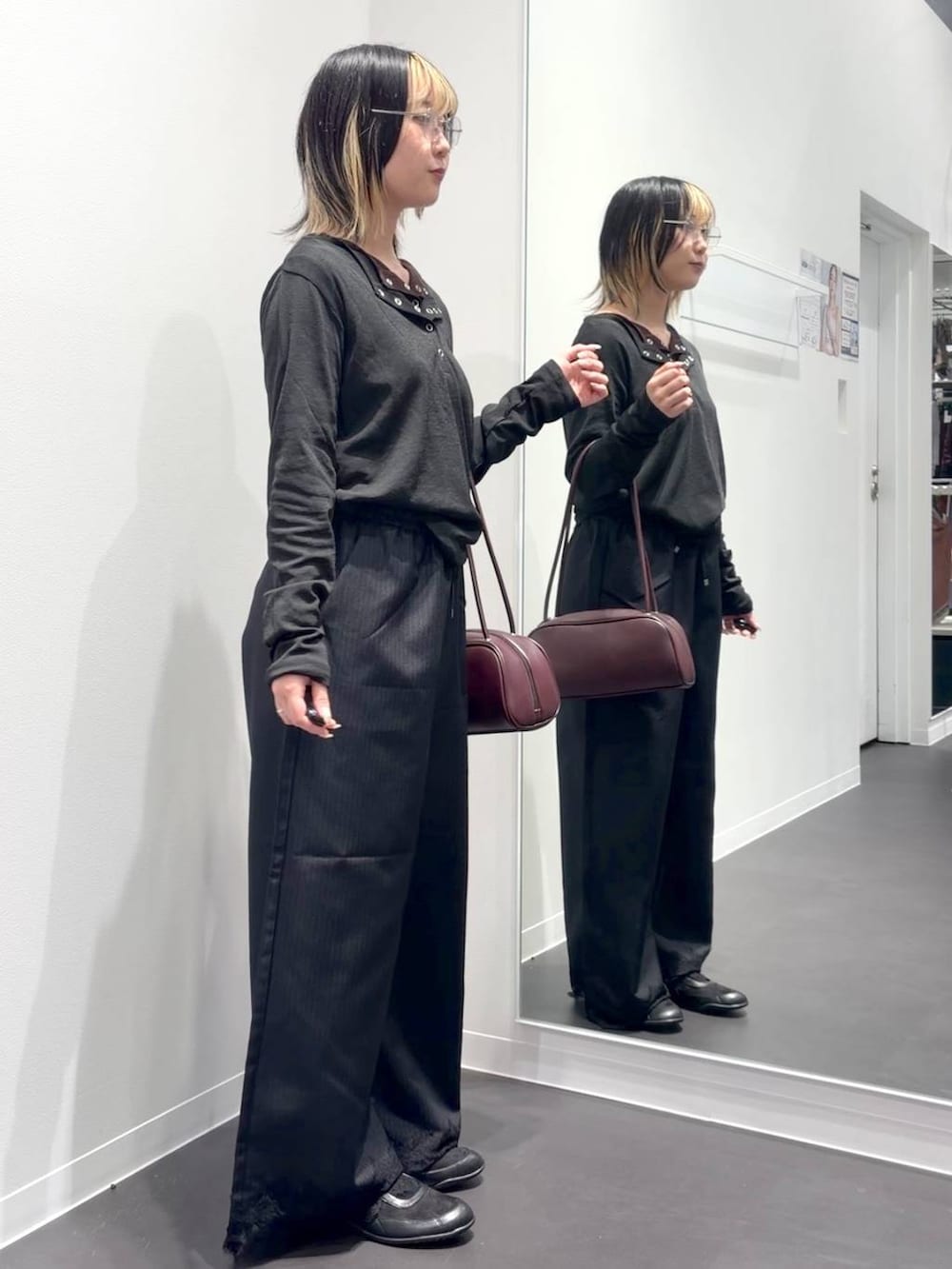 レッド系のボストンバッグ、ブラック系のスラックス、ブラック系のTシャツ/カットソーを着用したレディースの夏コーディネートの4枚目の写真