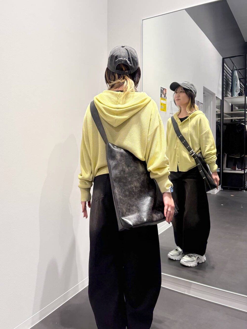 ブラック系のデニムパンツ、ブラック系のTシャツ/カットソー、ブラック系のショルダーバッグを着用したレディースの春コーディネートの3枚目の写真