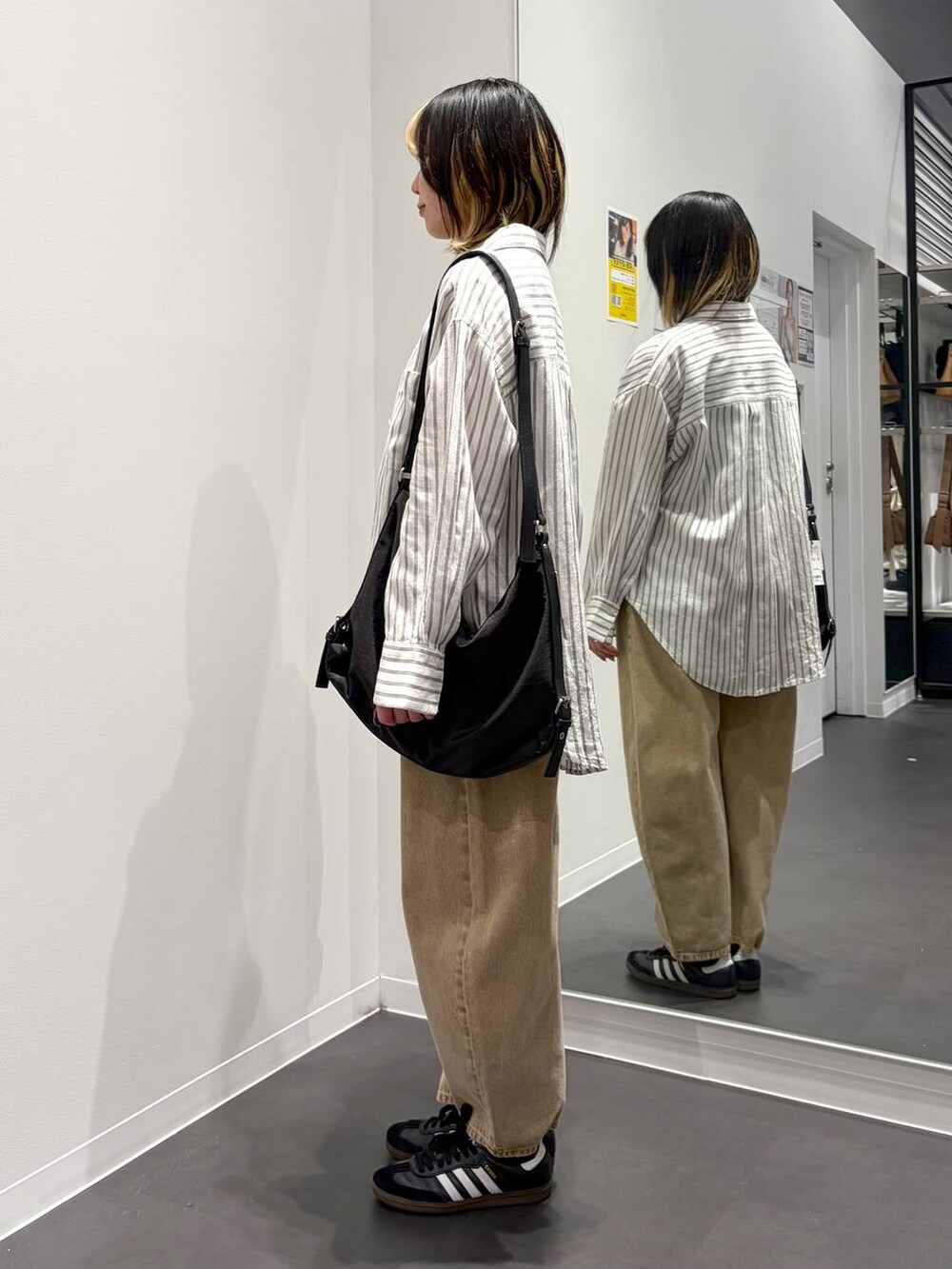 ベージュ系のデニムパンツ、ブラック系のショルダーバッグ、ホワイト系のシャツ/ブラウスを着用したレディースの春コーディネートの2枚目の写真
