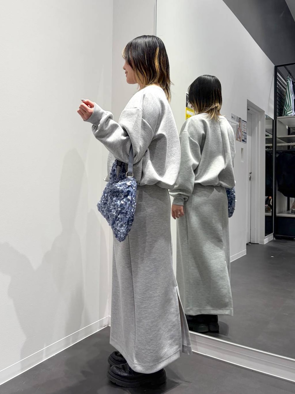 グレー系のスカート、グレー系のスウェット、ブルー系のショルダーバッグを着用したレディースの春コーディネートの2枚目の写真