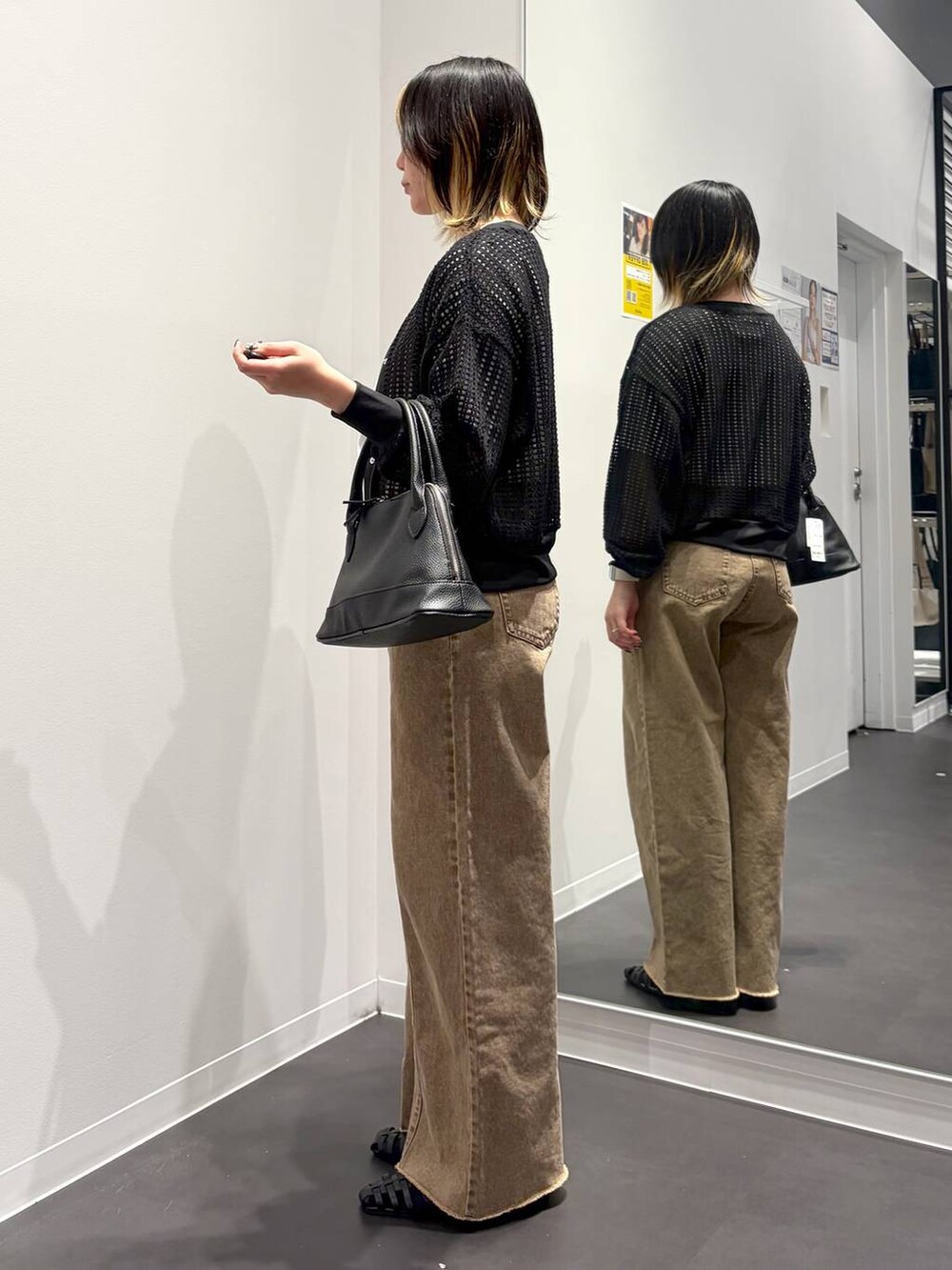 ブラック系のサンダル、ブラック系のハンドバッグ、ベージュ系のデニムパンツを着用したレディースの春コーディネートの2枚目の写真