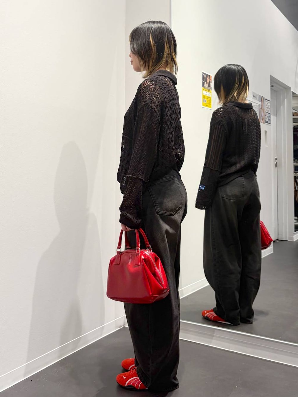 ブラック系のデニムパンツ、レッド系のスニーカー、ブラック系のタンクトップを着用したレディースの春コーディネートの2枚目の写真