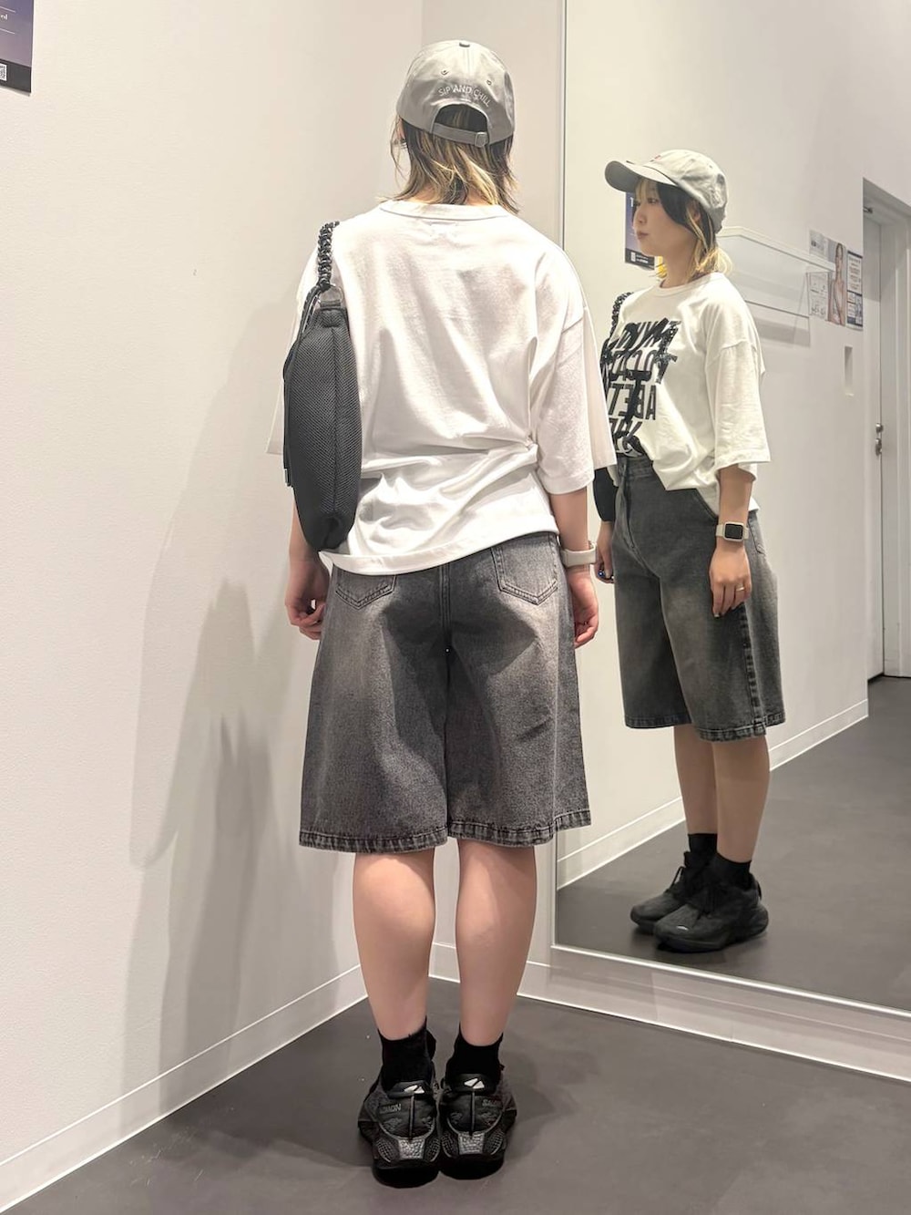 ブラック系のトートバッグ、ホワイト系のTシャツ/カットソー、ブラック系のデニムパンツを着用したレディースの夏コーディネートの3枚目の写真