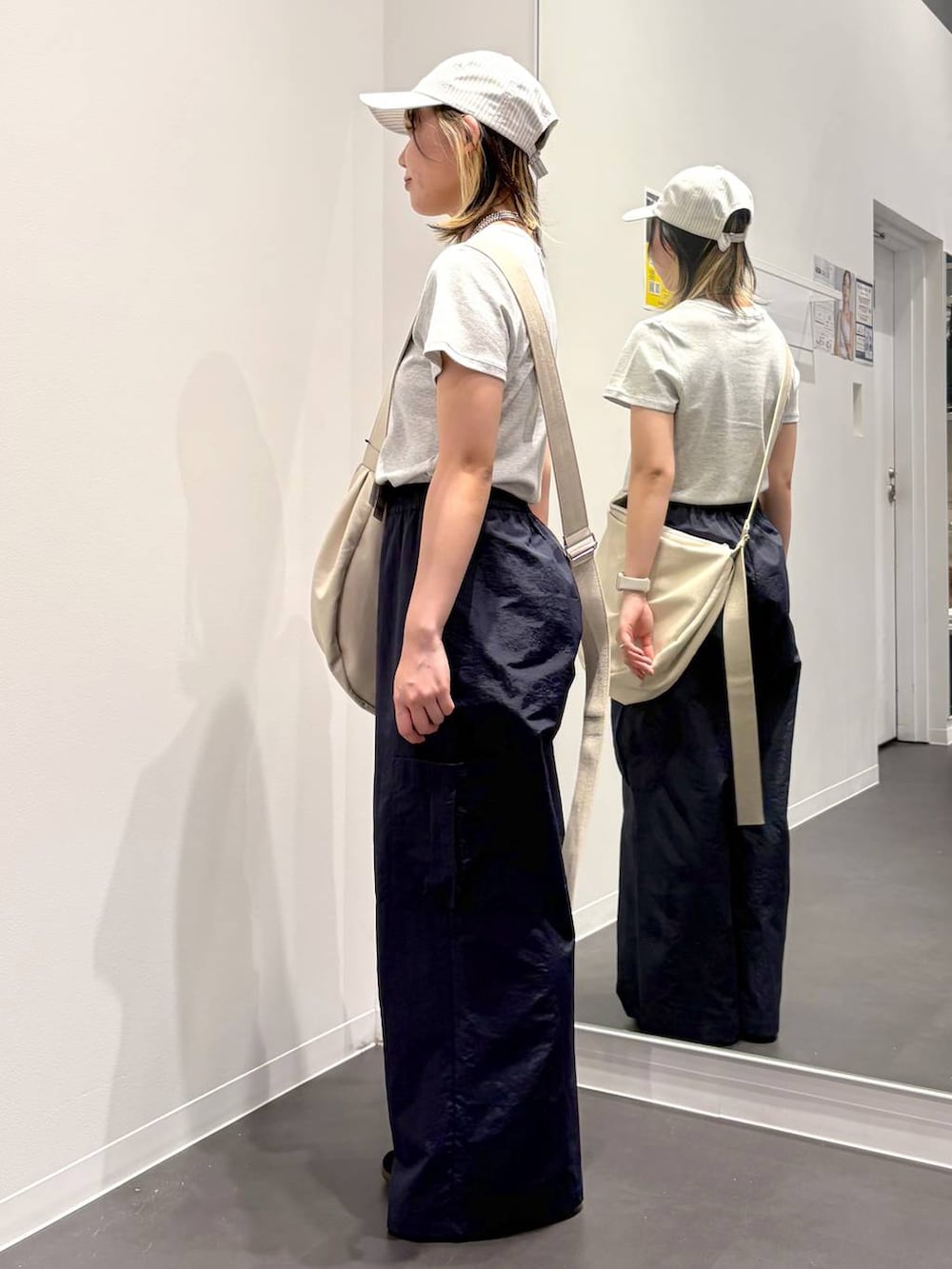 グレー系のTシャツ/カットソー、ブルー系のカーゴパンツ、ホワイト系のショルダーバッグを着用したレディースの春コーディネートの2枚目の写真