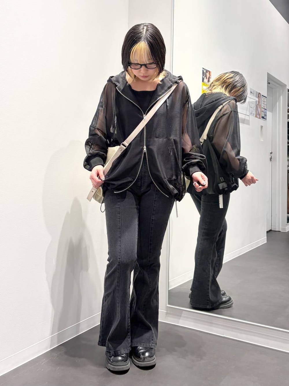ホワイト系のショルダーバッグ、ブラック系のデニムパンツ、ブラック系のタンクトップを着用したレディースの春コーディネートの5枚目の写真