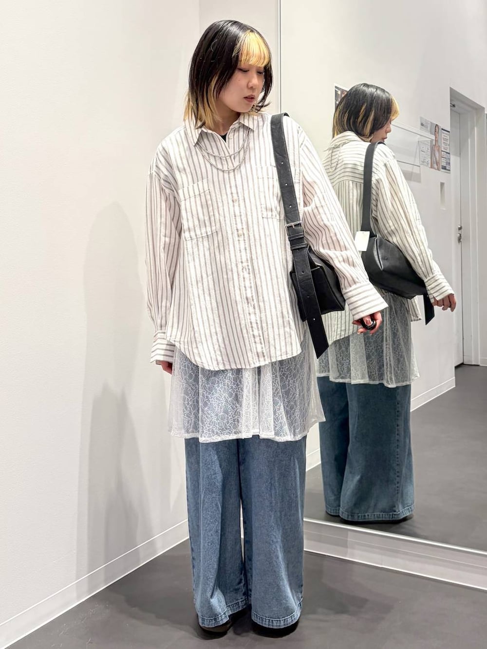 ブラック系のショルダーバッグ、ホワイト系のシャツ/ブラウス、ブルー系のデニムパンツを着用したレディースの春コーディネートの5枚目の写真