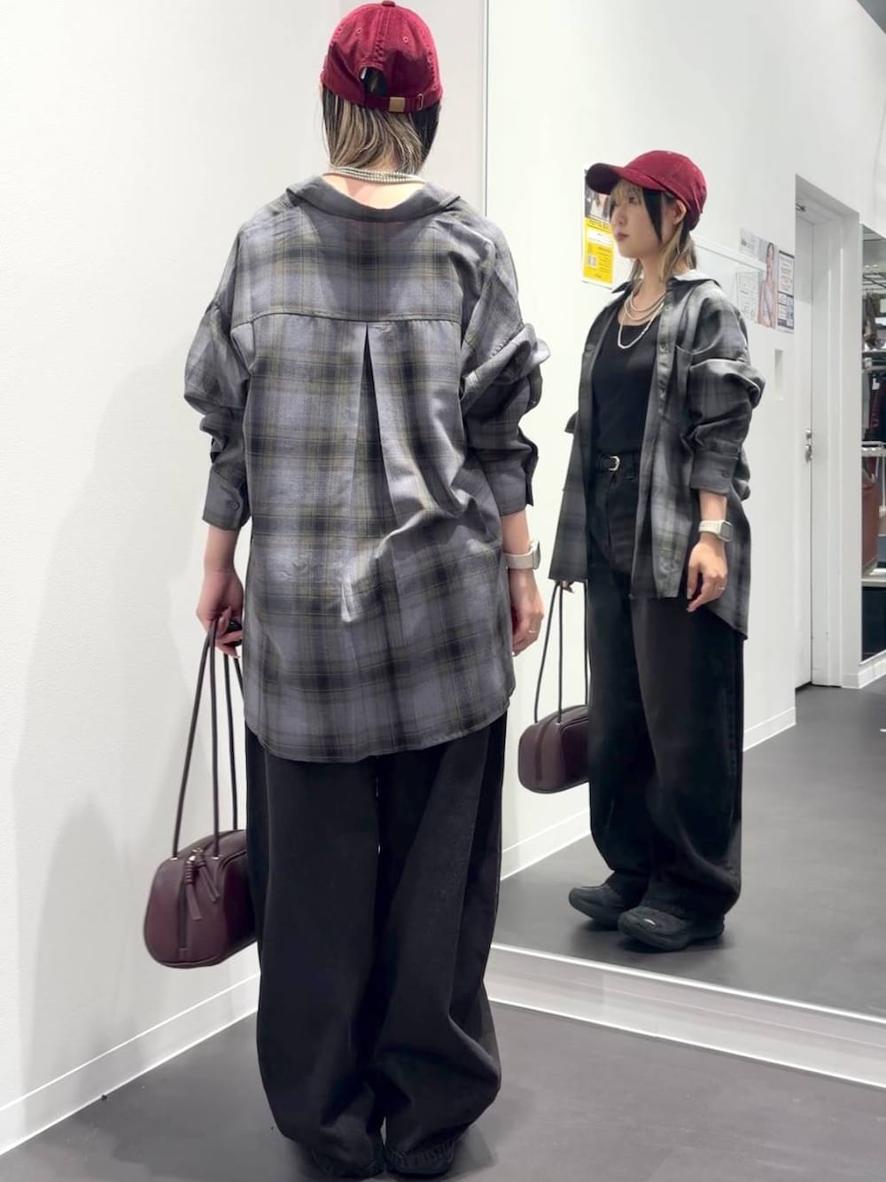 グレー系のシャツ/ブラウス、レッド系のボストンバッグ、ブラック系のデニムパンツを着用したレディースの秋コーディネートの3枚目の写真