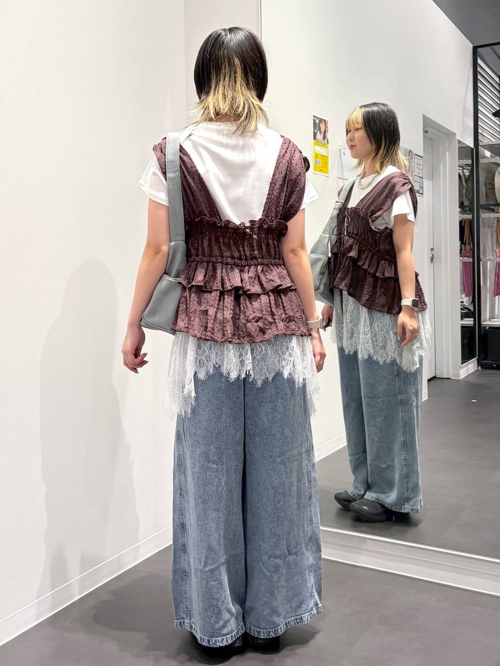 グレー系のショルダーバッグ、ブラウン系のベスト、ホワイト系のTシャツ/カットソーを着用したレディースの夏コーディネートの3枚目の写真