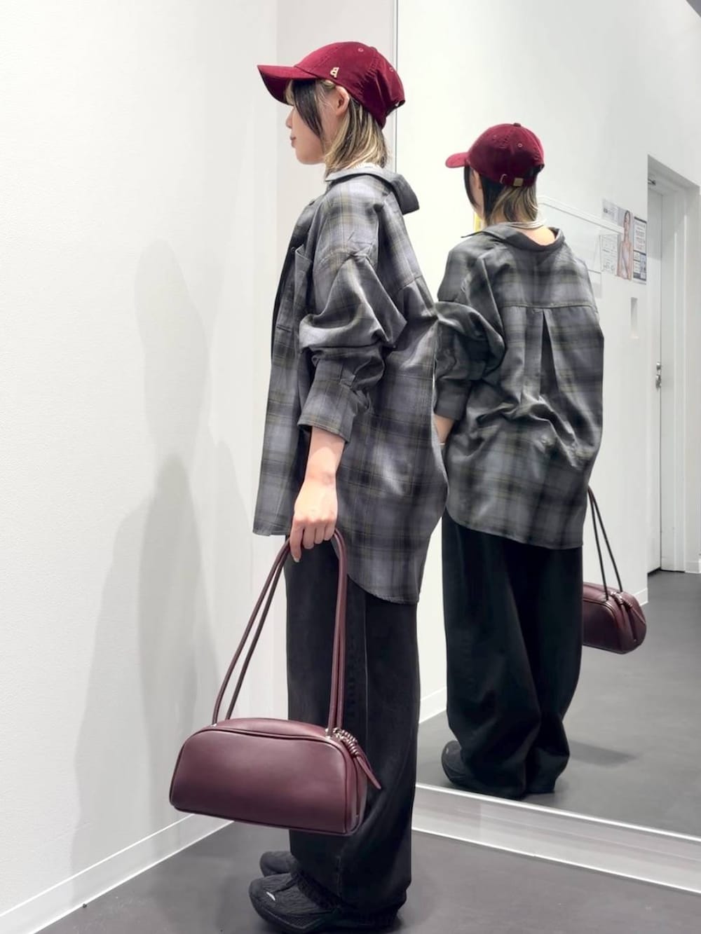 グレー系のシャツ/ブラウス、レッド系のボストンバッグ、ブラック系のデニムパンツを着用したレディースの秋コーディネートの2枚目の写真