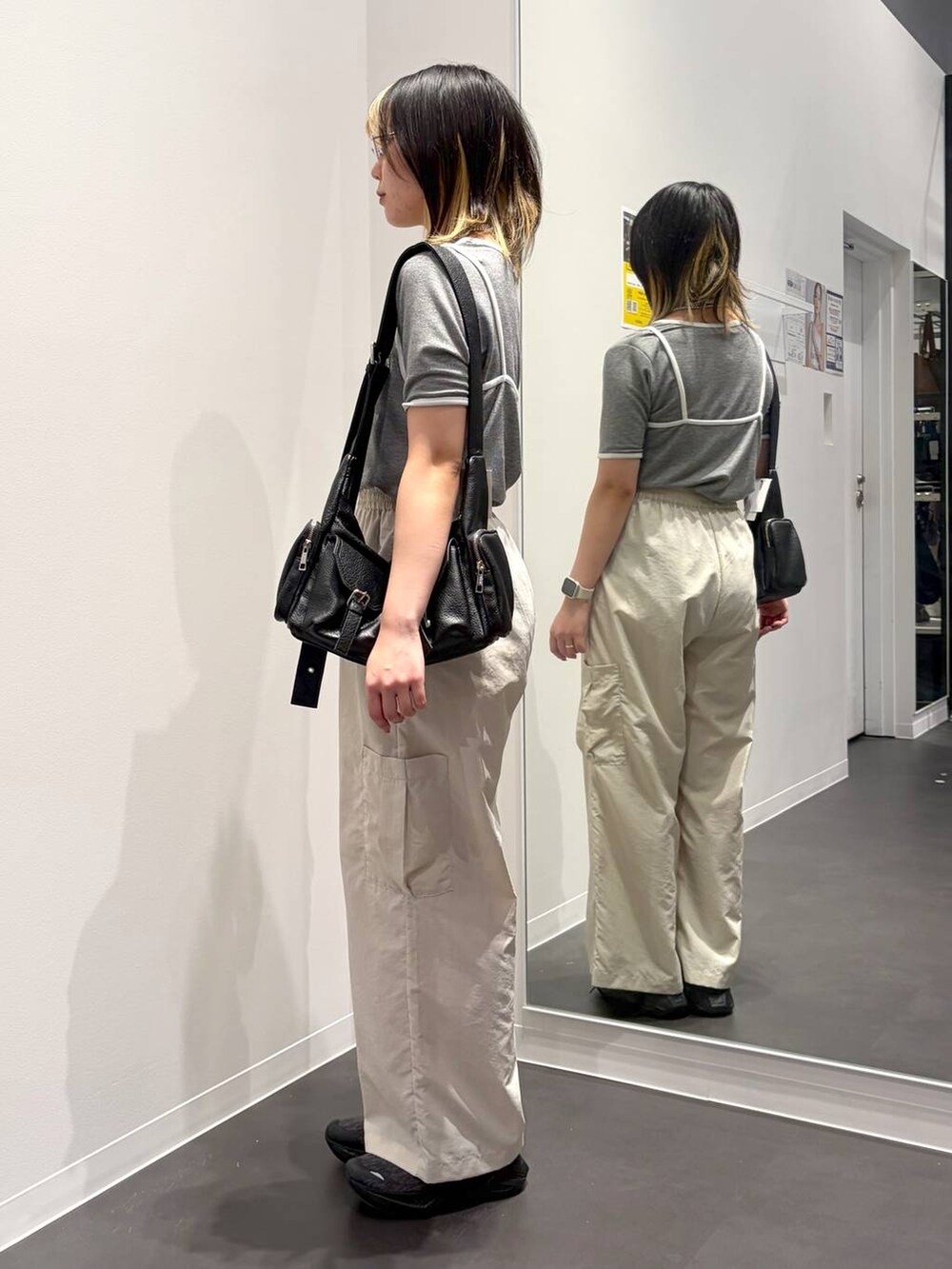 ブラック系のショルダーバッグ、ベージュ系のカーゴパンツ、グレー系のTシャツ/カットソーを着用したレディースの春コーディネートの2枚目の写真