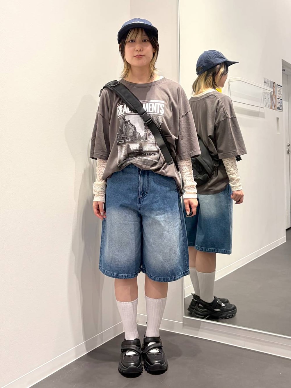 ブラック系のスニーカー、ブラック系のボディバッグ/ウエストポーチ、ホワイト系のTシャツ/カットソーを着用したレディースの春コーディネートの5枚目の写真