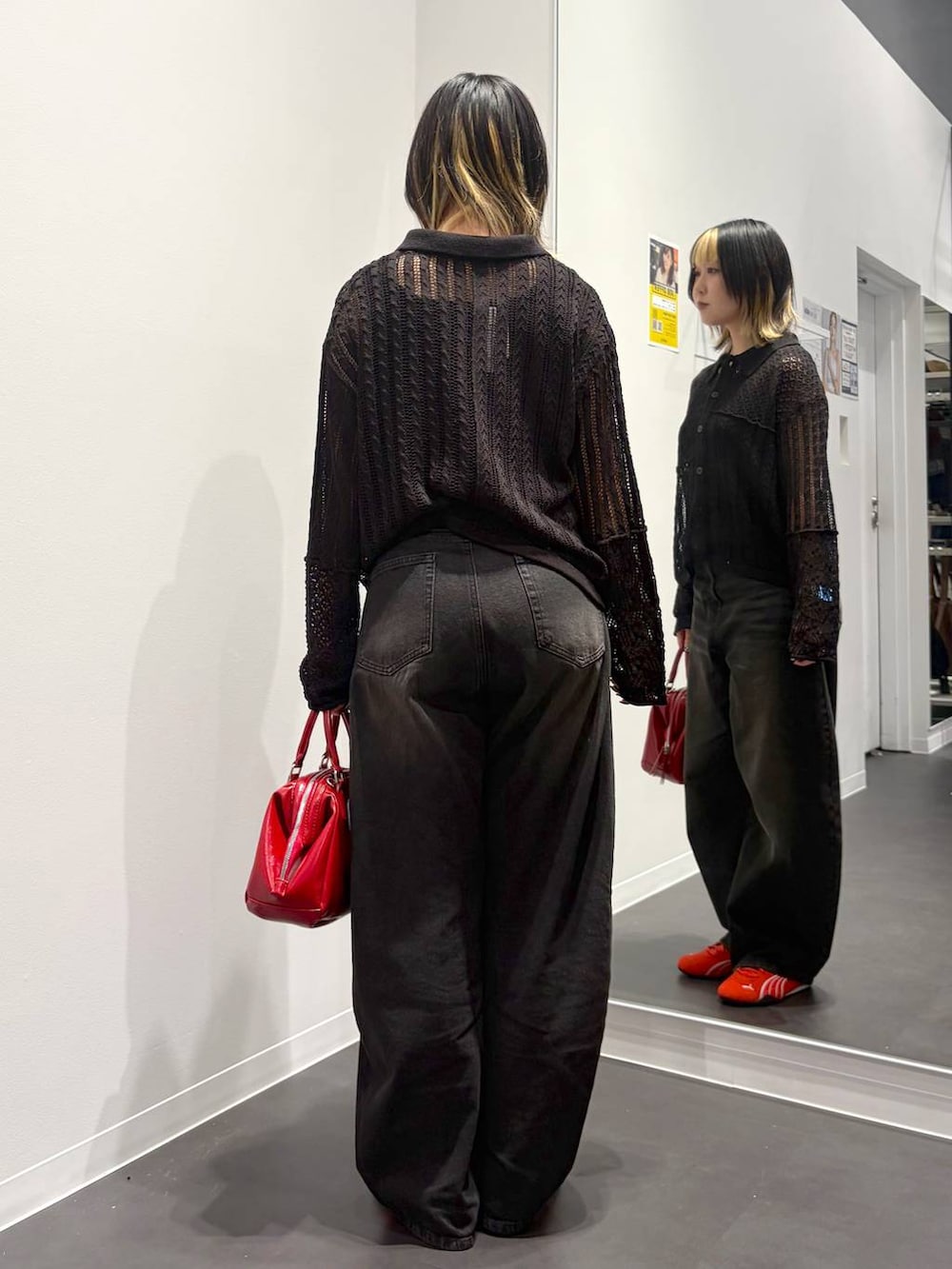 ブラック系のデニムパンツ、レッド系のスニーカー、ブラック系のタンクトップを着用したレディースの春コーディネートの3枚目の写真