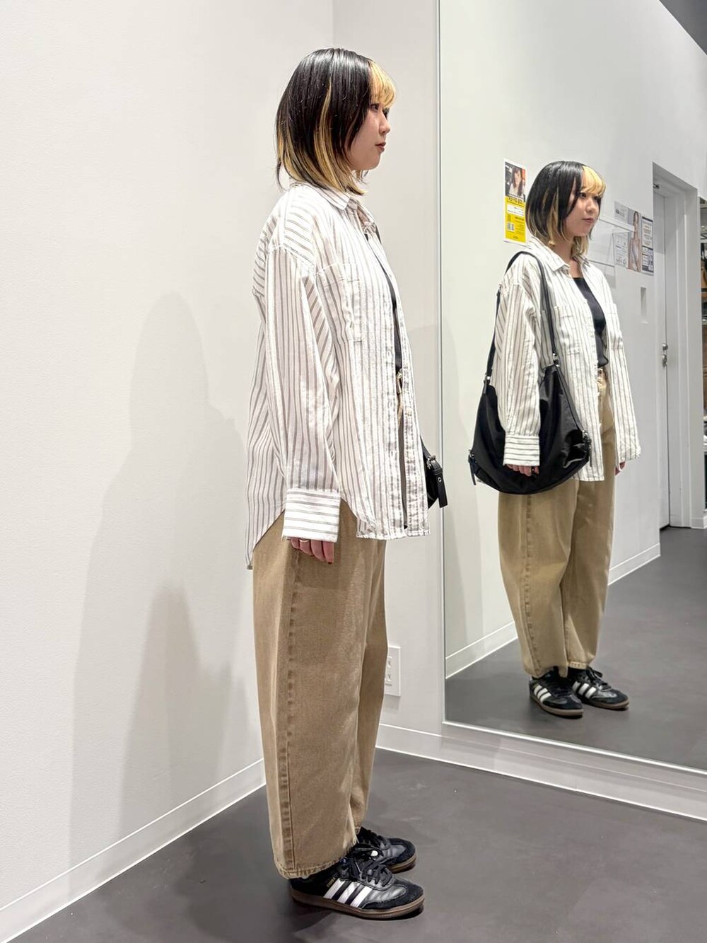 ベージュ系のデニムパンツ、ブラック系のショルダーバッグ、ホワイト系のシャツ/ブラウスを着用したレディースの春コーディネートの4枚目の写真