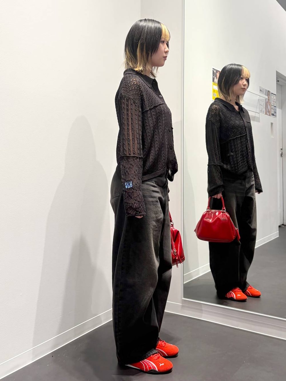ブラック系のデニムパンツ、レッド系のスニーカー、ブラック系のタンクトップを着用したレディースの春コーディネートの4枚目の写真