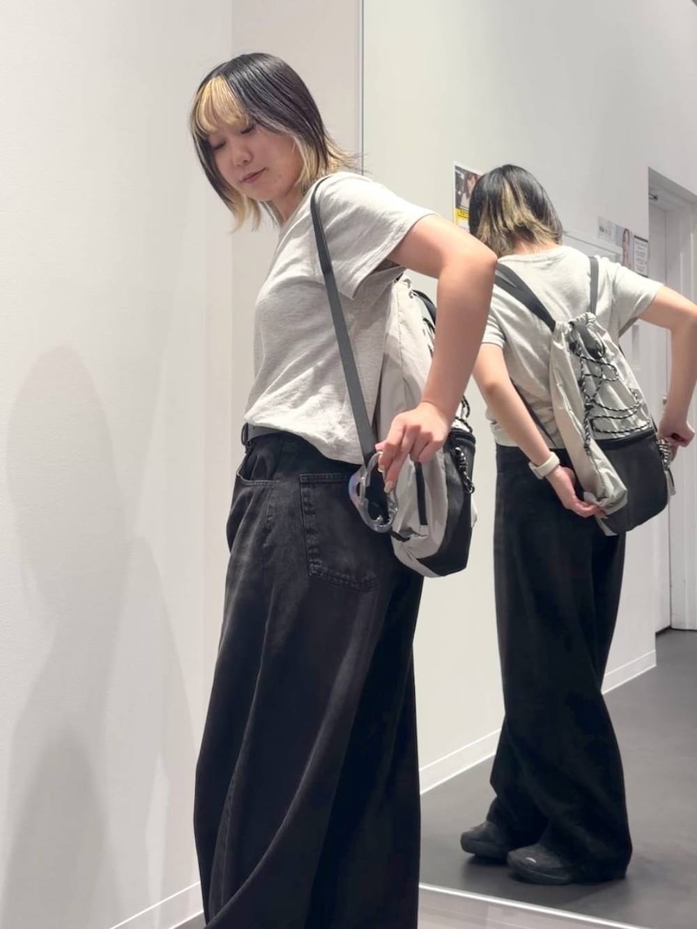 ブラック系のデニムパンツ、グレー系のバックパック/リュック、グレー系のTシャツ/カットソーを着用したレディースの夏コーディネートの2枚目の写真