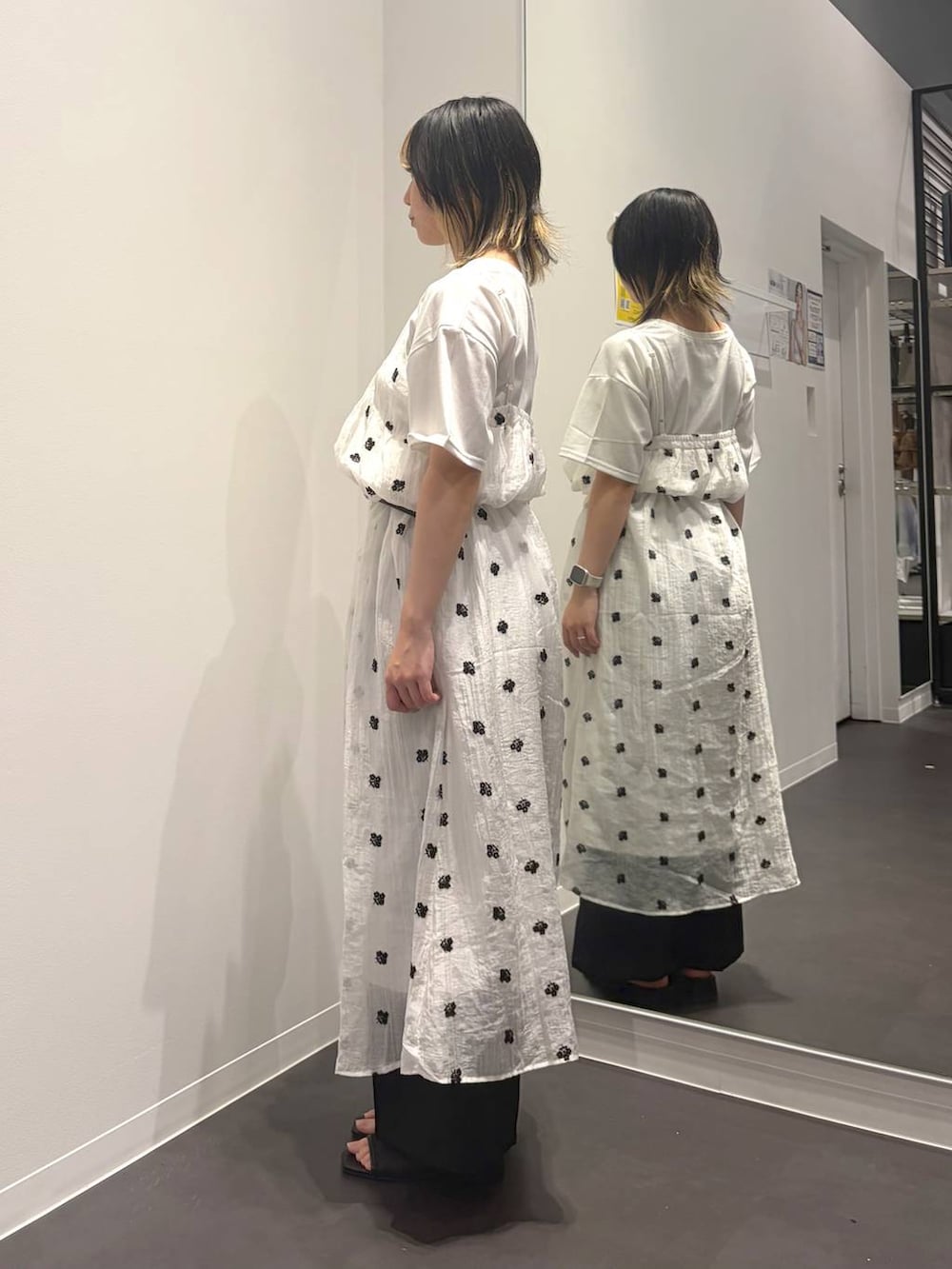 ホワイト系のワンピース、ブラック系のサンダル、ホワイト系のTシャツ/カットソーを着用したレディースの夏コーディネートの2枚目の写真