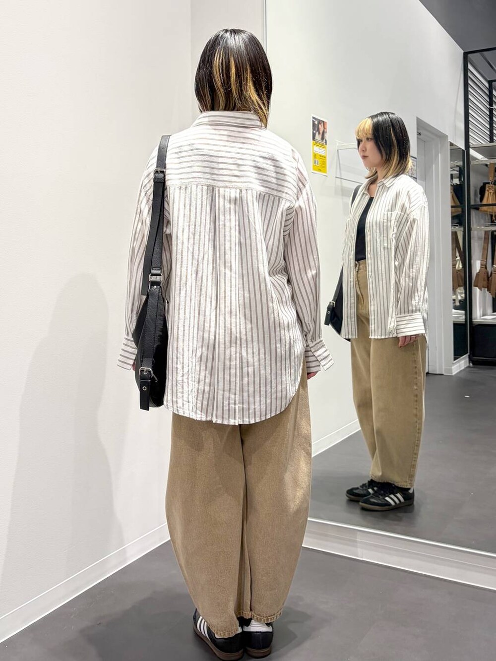 ベージュ系のデニムパンツ、ブラック系のショルダーバッグ、ホワイト系のシャツ/ブラウスを着用したレディースの春コーディネートの3枚目の写真