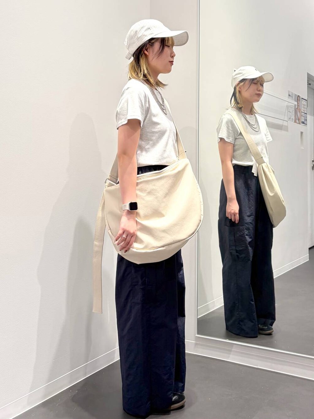 グレー系のTシャツ/カットソー、ブルー系のカーゴパンツ、ホワイト系のショルダーバッグを着用したレディースの春コーディネートの3枚目の写真