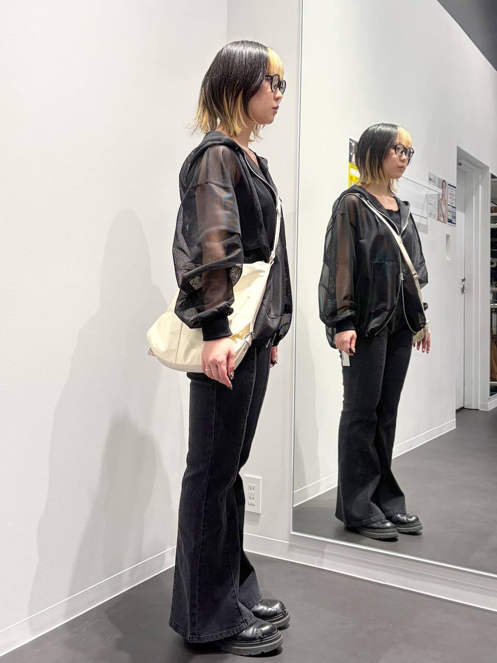ホワイト系のショルダーバッグ、ブラック系のデニムパンツ、ブラック系のタンクトップを着用したレディースの春コーディネートの2枚目の写真