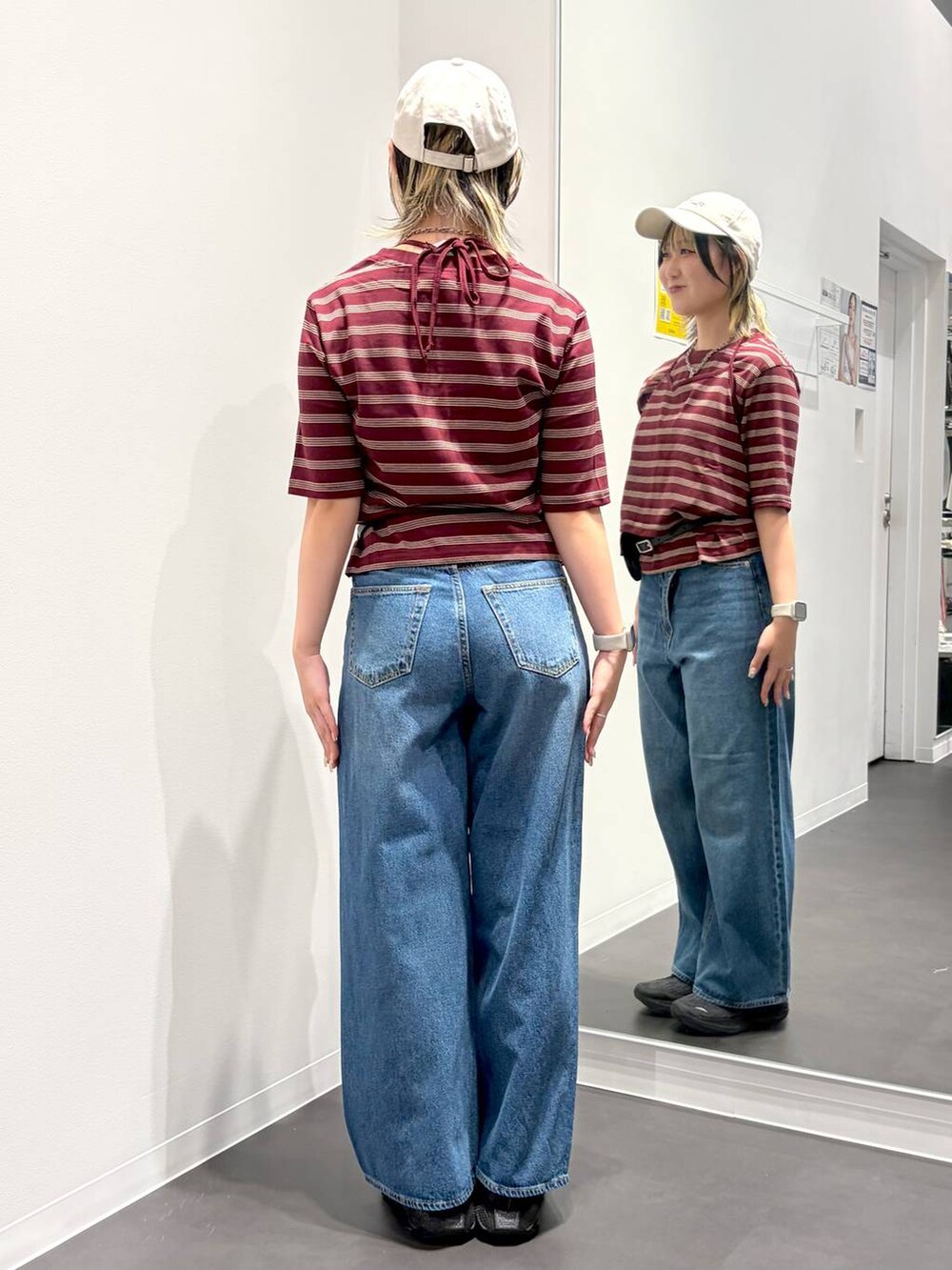ブルー系のデニムパンツ、レッド系のTシャツ/カットソー、ブラック系のベルトを着用したレディースの夏コーディネートの3枚目の写真