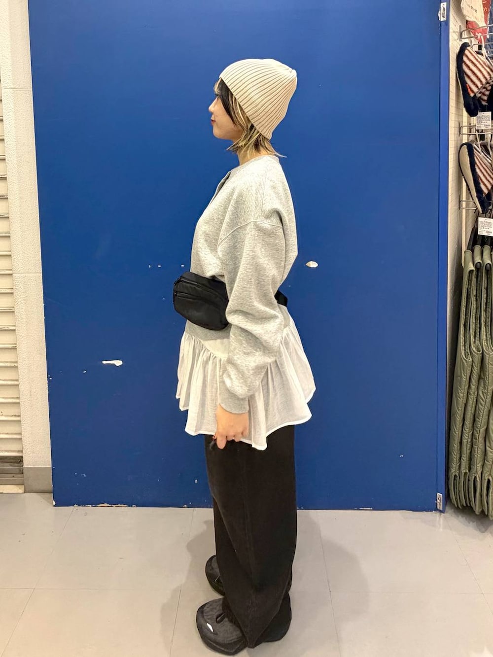 ブラック系のボディバッグ/ウエストポーチ、ブラック系のデニムパンツ、ホワイト系のタンクトップを着用したレディースの秋コーディネートの2枚目の写真