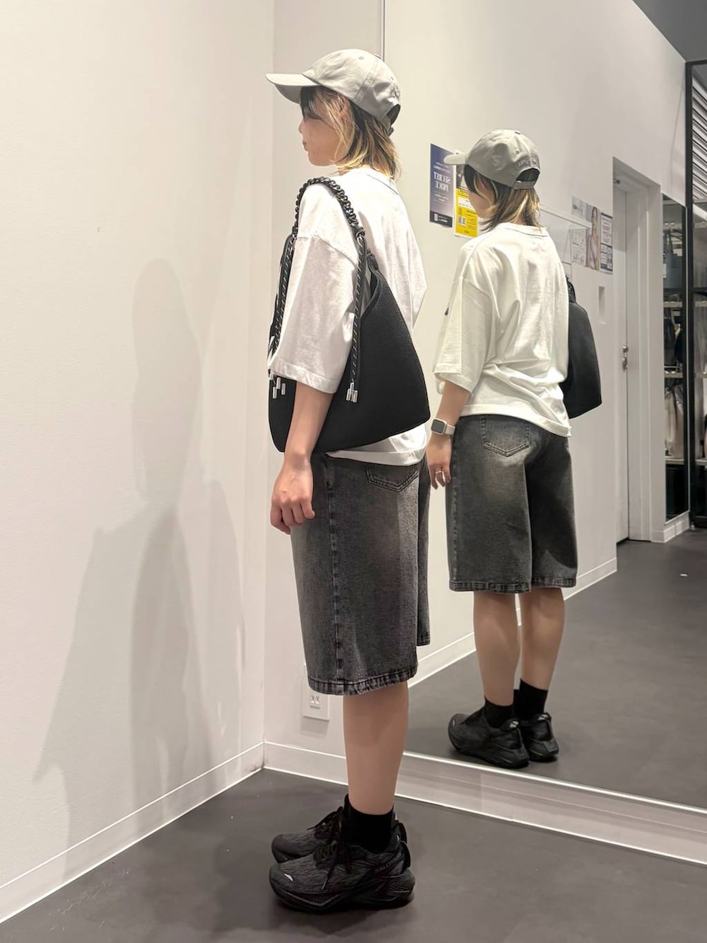 ブラック系のトートバッグ、ホワイト系のTシャツ/カットソー、ブラック系のデニムパンツを着用したレディースの夏コーディネートの2枚目の写真