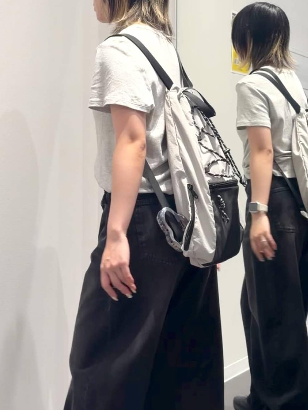 ブラック系のデニムパンツ、グレー系のバックパック/リュック、グレー系のTシャツ/カットソーを着用したレディースの夏コーディネートの3枚目の写真