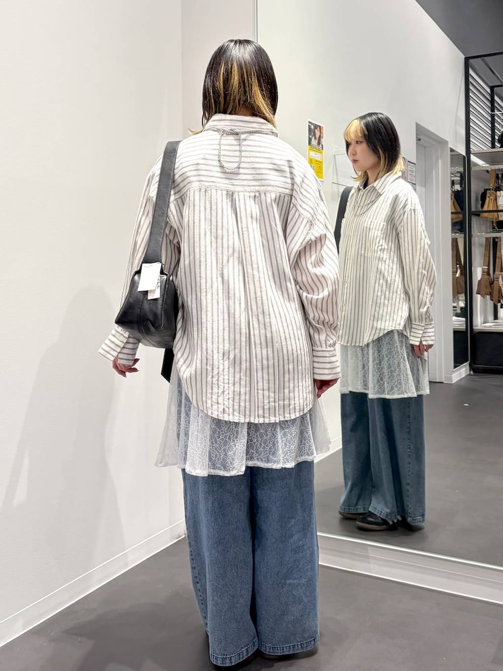 ブラック系のショルダーバッグ、ホワイト系のシャツ/ブラウス、ブルー系のデニムパンツを着用したレディースの春コーディネートの3枚目の写真