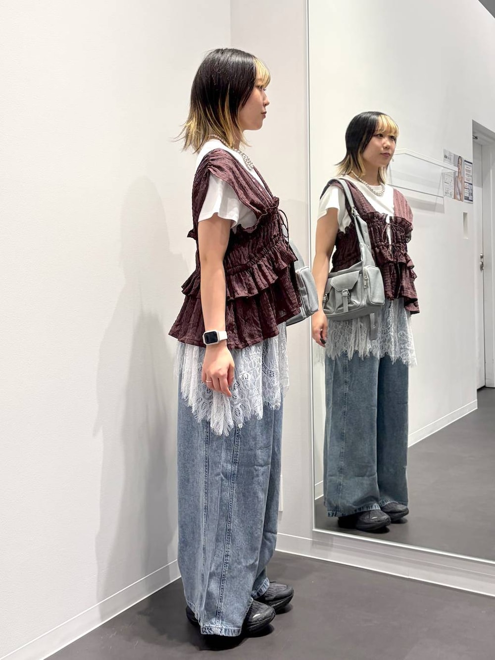 グレー系のショルダーバッグ、ブラウン系のベスト、ホワイト系のTシャツ/カットソーを着用したレディースの夏コーディネートの4枚目の写真