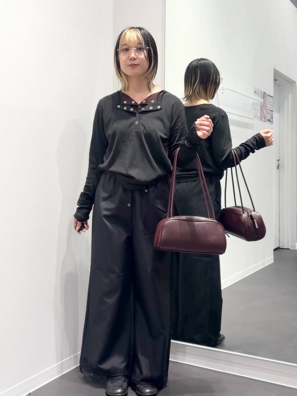 レッド系のボストンバッグ、ブラック系のスラックス、ブラック系のTシャツ/カットソーを着用したレディースの夏コーディネートの5枚目の写真
