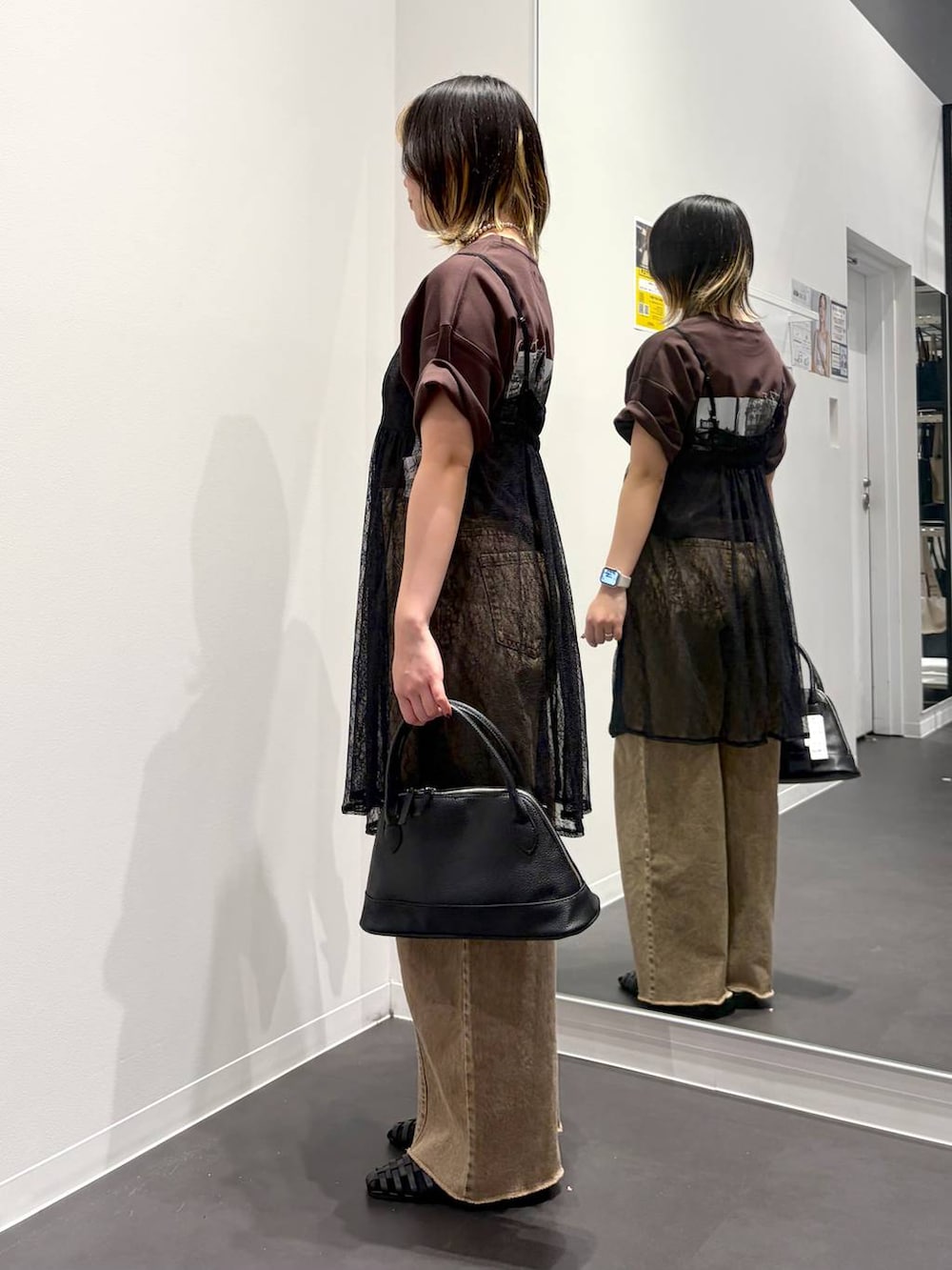 ブラック系のサンダル、ブラック系のハンドバッグ、ベージュ系のデニムパンツを着用したレディースの春コーディネートの2枚目の写真