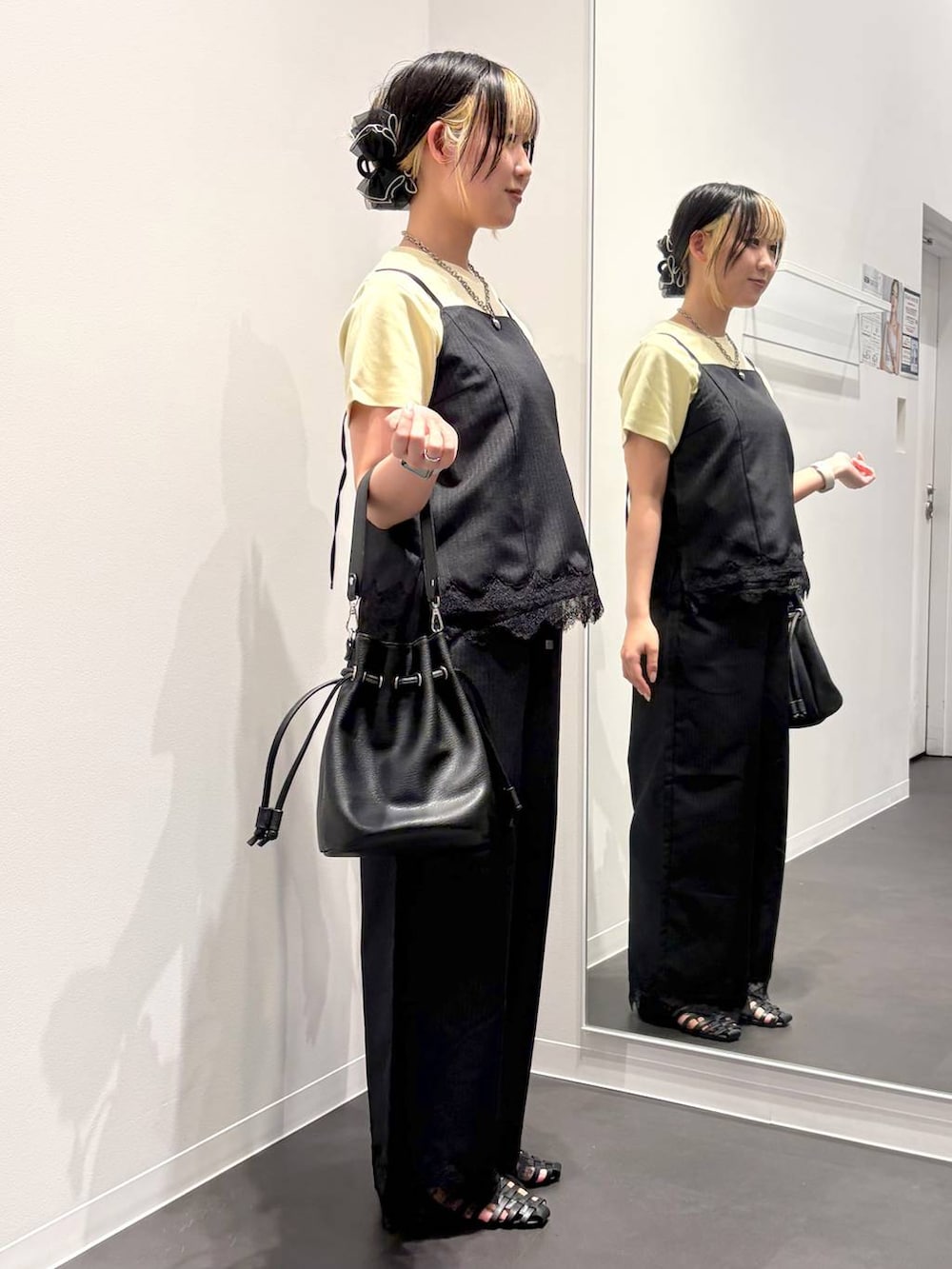 ブラック系のスラックス、ブラック系のキャミソール、ブラック系のサンダルを着用したレディースの夏コーディネートの4枚目の写真