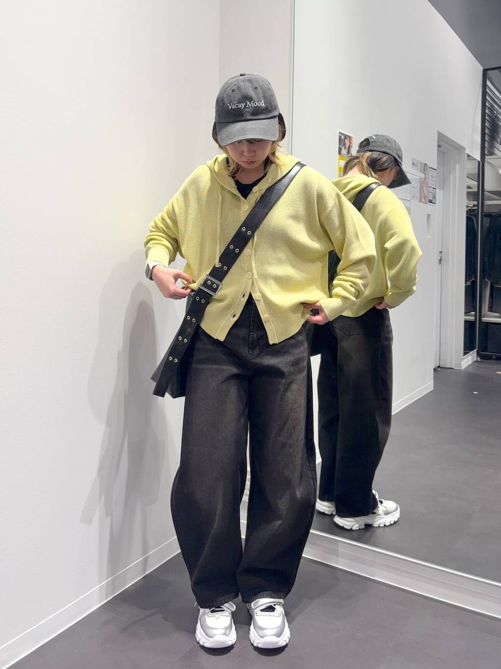 ブラック系のデニムパンツ、ブラック系のショルダーバッグ、シルバー系のスニーカーを着用したレディースの春コーディネートの5枚目の写真