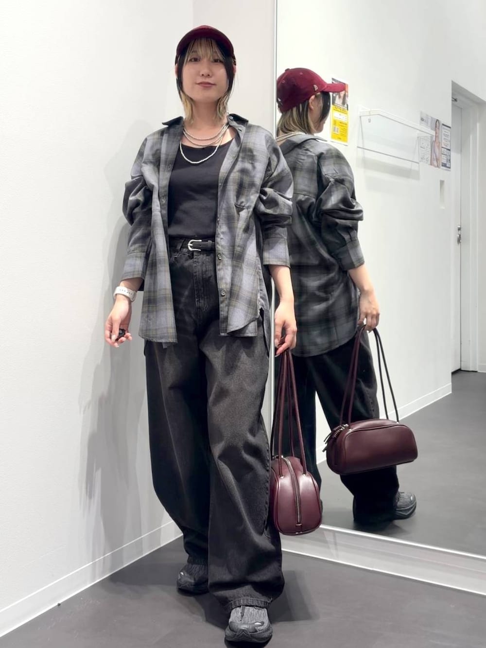 グレー系のシャツ/ブラウス、レッド系のボストンバッグ、ブラック系のデニムパンツを着用したレディースの秋コーディネートの5枚目の写真