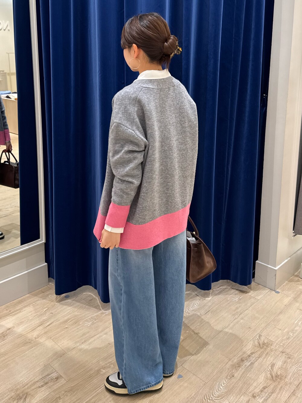 グレー系のカーディガン/ボレロ、ホワイト系のシャツ/ブラウス、ブルー系のデニムパンツを着用したレディースの秋コーディネートの3枚目の写真